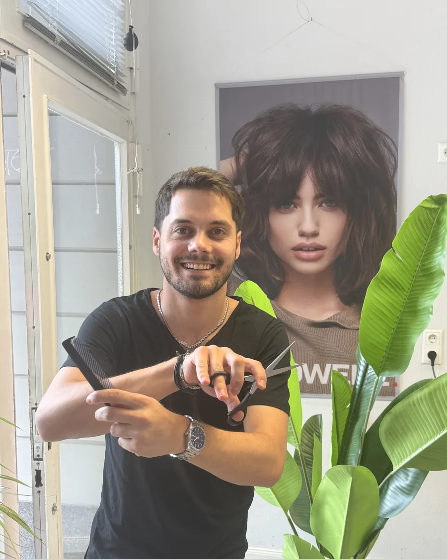 Dogus, Damen-Friseur bei Friseur Team Rudolph, mit Schere und Kamm im Salon.